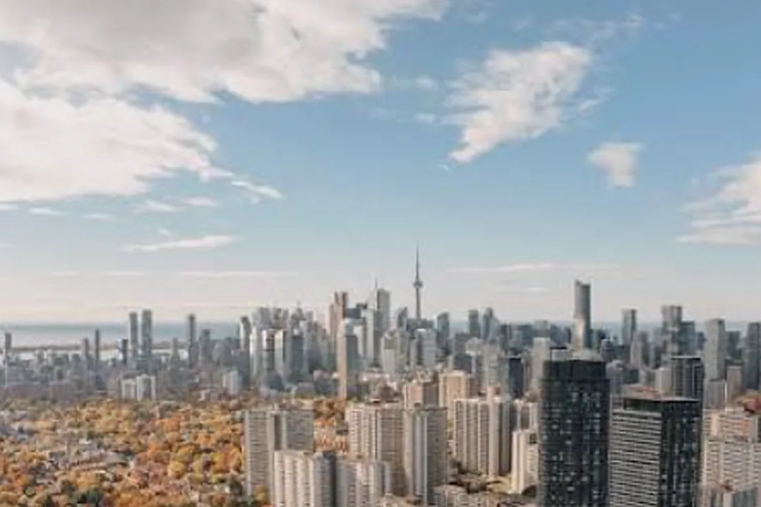 Edificios de una ciudad grande bajo un cielo azul con nubes blancas